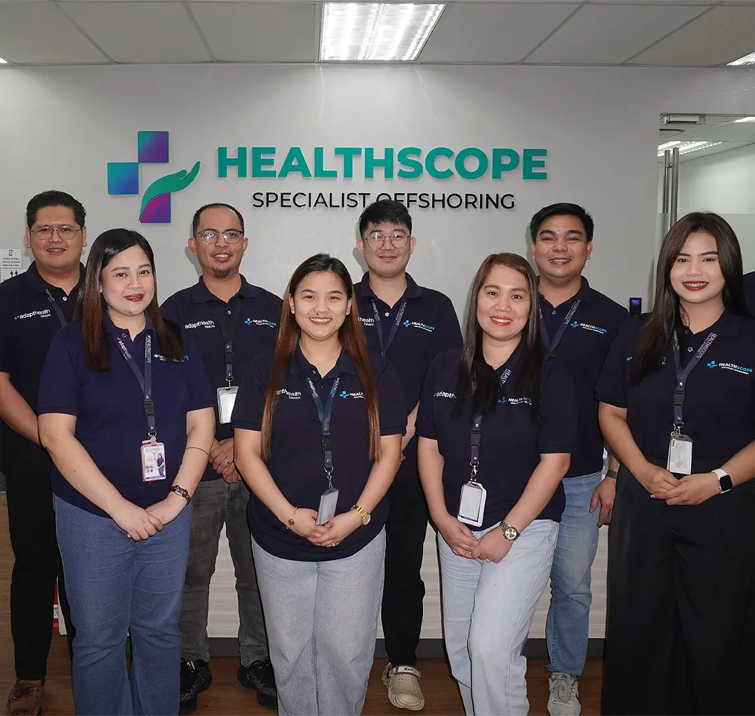 Healthscope team members standing together in front of the Healthscope office sign